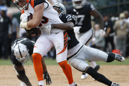 Cincinnati Bengals tight end Tyler Eifert (85) runs as Oakland Raiders cornerback Charles Woodson (24) tries to tackle him during the first half of an NFL football game in Oakland, Calif., Sunday, Sept. 13, 2015. (AP Photo/Tony Avelar)