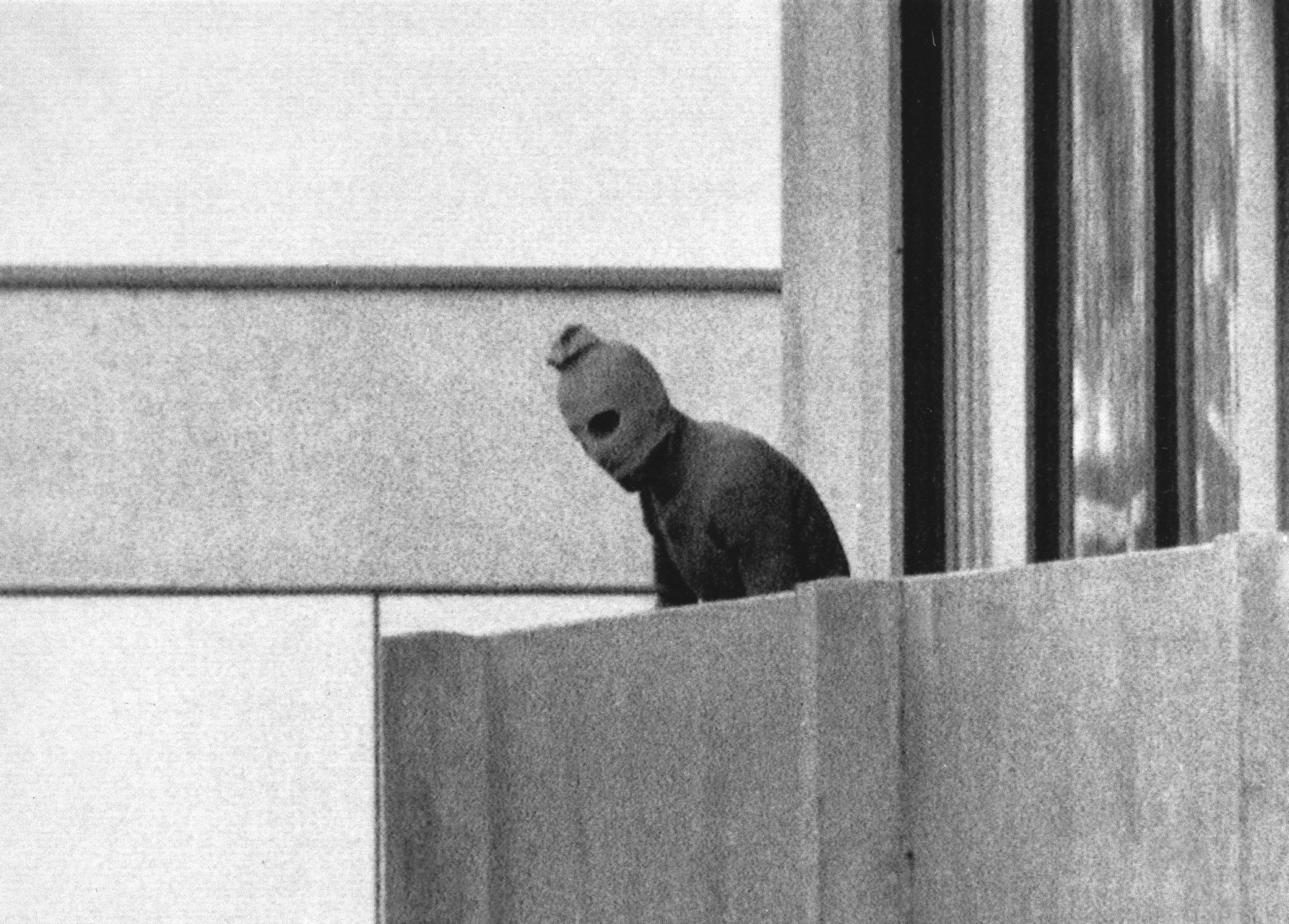 FILE - In this Sept. 5, 1972, file photo, a member of the Arab Commando group which seized members of the Israeli Olympic Team at their quarters at the Munich Olympic Village appears with a hood over his face on the balcony of the village building where the commandos held several members of the Israeli team hostage.  (AP Photo/Kurt Strumpf, File)