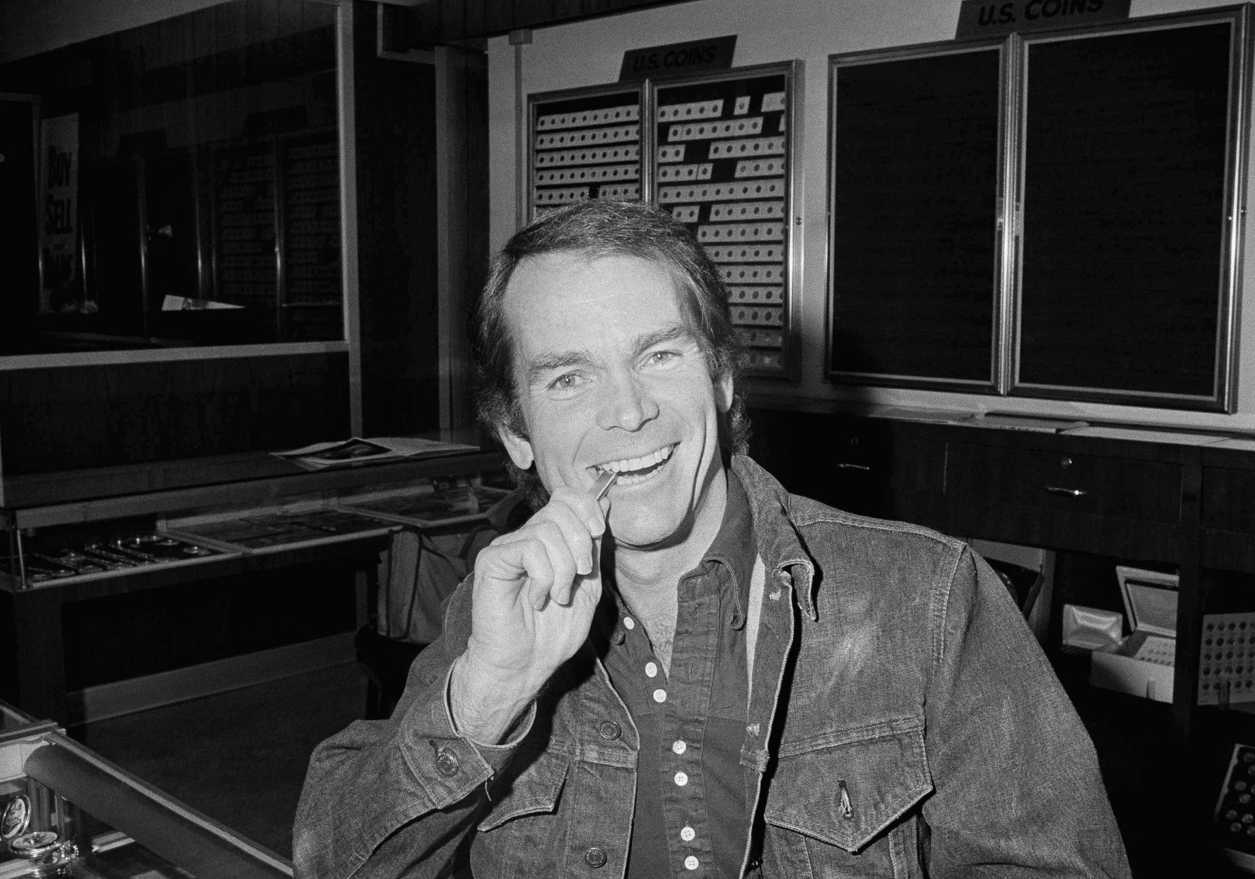 Actor Dean Jones, who wanted to be the first Californian to buy a gold bullion in more than 40 years, bites the two-ounce bar he bought in Los Angeles, Dec. 31, 1974, one second after the purchase became legal last night. He had been waiting in the gold dealers' office. The little bar coast him $395. (AP Photo/Harold Filan)