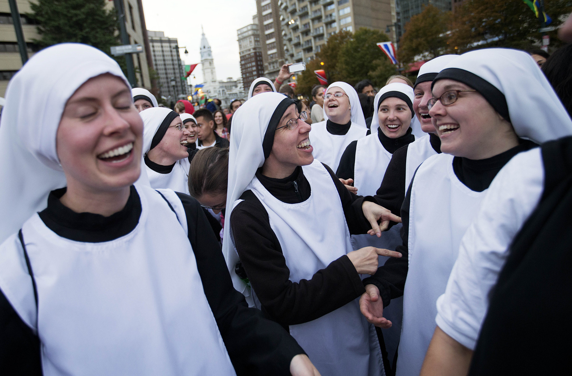 CORRECTS TO HANDMAIDS OF THE HEART OF JESUS FROM HANDMADE AT THE HEART OF JESUS- Sisters with Handmaids of the Heart of Jesus, out of New Ulm, Minn., sing along to music as they wait for a parade with Pope Francis to start along Benjamin Franklin Parkway Saturday, Sept. 26, 2015, in Philadelphia. (AP Photo/David Goldman)