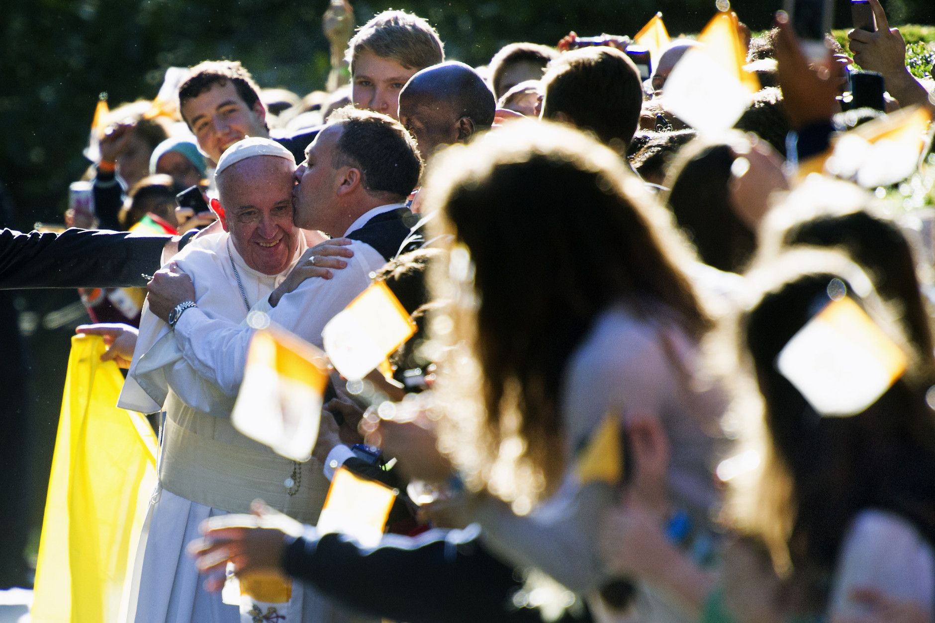 A man kisses Pope Francis while he greets well-wishers outside the Apostolic Nunciature, the Vatican's diplomatic mission in Washington, Wednesday, Sept. 23, 2015, prior to his departure to the White House where President Barack Obama will host a state arrival ceremony.  (AP Photo/Cliff Owen)