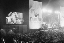On this date in 1985, rock and country music artists participated in "Farm Aid," a concert staged in Champaign, Illinois, to help the nation's farmers. Here, John Cougar Mellencamp performs.  (AP Photo/Seth Perlman)