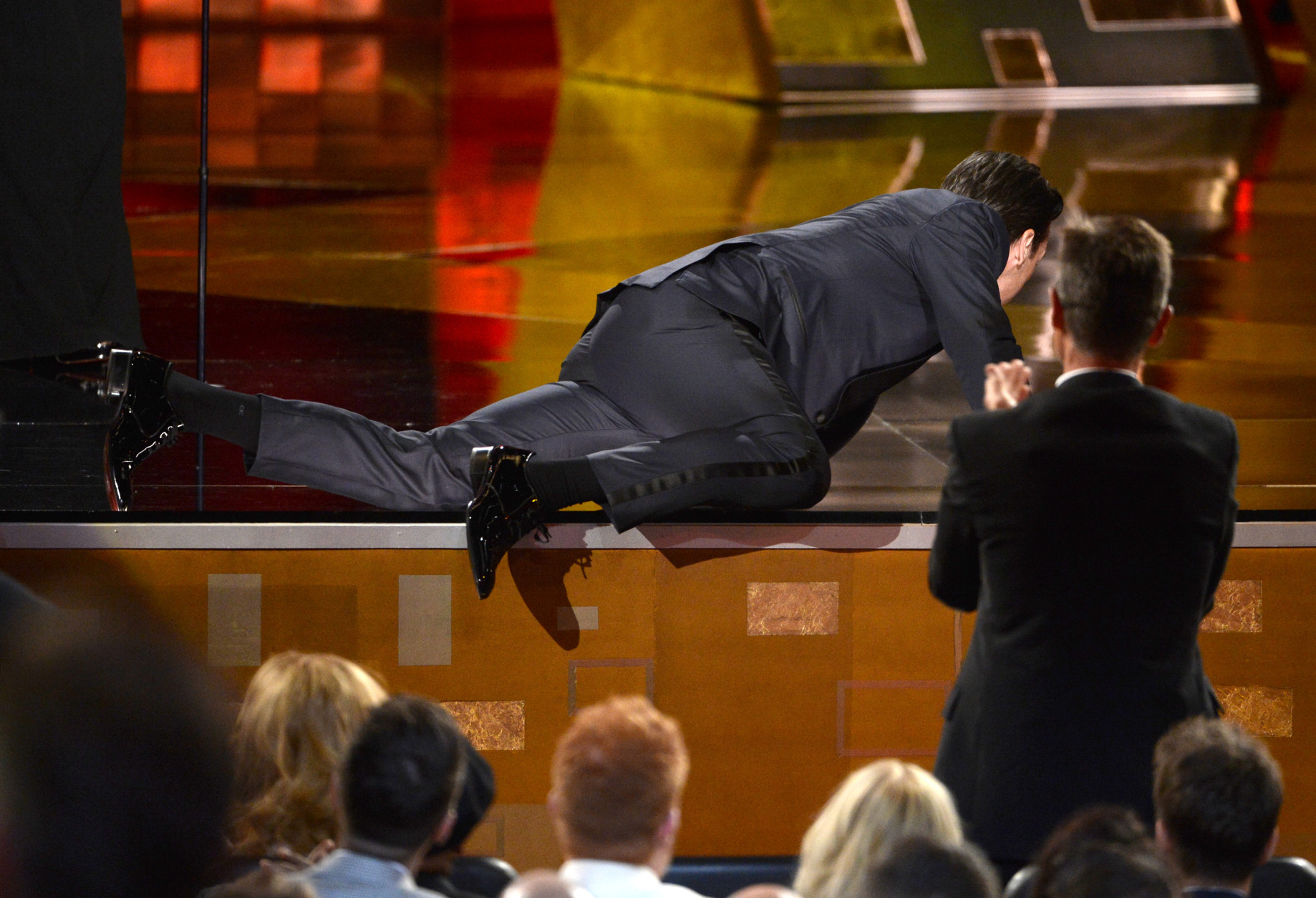 Jon Hamm crawls on stage to accept the award for outstanding lead actor in a drama series for Mad Men at the 67th Primetime Emmy Awards on Sunday, Sept. 20, 2015, at the Microsoft Theater in Los Angeles. (Photo by Phil McCarten/Invision for the Television Academy/AP Images)