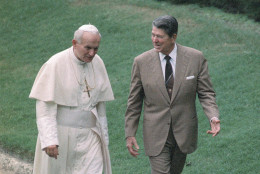 On this date in 1987, Pope John Paul II arrived in Miami, where he was welcomed by President Ronald Reagan and first lady Nancy Reagan as he began a 10-day tour of the United States. (AP Photo/Scott Stewart, File)