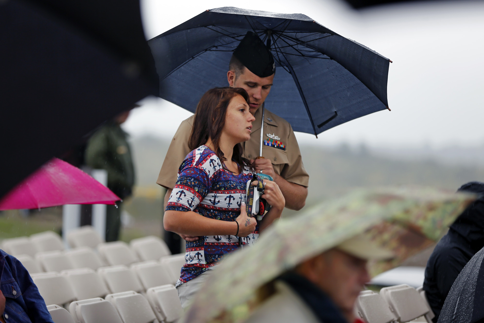 Andrew and Angela Garrison of Johnstown, Pa., stand under an umbrella as rain falls on the dedication of the Flight 93 National Memorial Visitor Center in Shanksville, Pa, on Thursday, Sept. 10, 2015. (AP Photo/Gene J. Puskar)