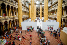 Visitors enjoy "The Beach", an interactive architectural installation inside the National Building Museum in Washington, Friday, July 17, 2015. The Beach, which spans the length of the museum's Great Hall, was created in partnership with Snarkitecture, and covers 10,000 square feet and includes an ocean of nearly one million recyclable translucent plastic balls. (AP Photo/Andrew Harnik)