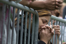 Milagros Orengo of Egg Harbor N.J., and born in the Dominican Republic, prays behind a barricade at Independence Mall in Philadelphia, as a Mass with Pope Francis at the Cathedral Basilica of Sts. Peter and Paul is projected on a large screen, Saturday, Sept. 26, 2015. (AP Photo/Carolyn Kaster)