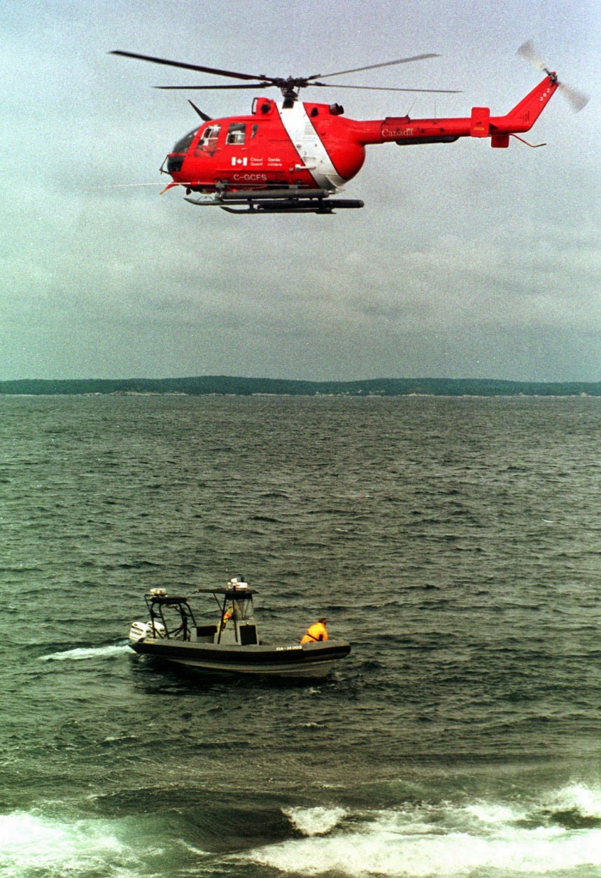 On this date in 1998, a Swissair MD-11 jetliner crashed off Nova Scotia, killing all 229 people aboard. Here, a Canadian Coast Guard helicopter hovers above a Coast Guard search boat off Peggy's Cove, Nova Scotia, Friday, Sept. 11, 1998. The two were part of the on-going search effort for debris from Swissair Flight 111. (AP Photo/Steven Senne)