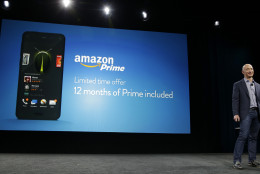 Amazon CEO Jeff Bezos stands next to a graphic that shows that the new Amazon Fire Phone comes with a free year of Amazon Prime, Wednesday, June 18, 2014, in Seattle. (AP Photo/Ted S. Warren)