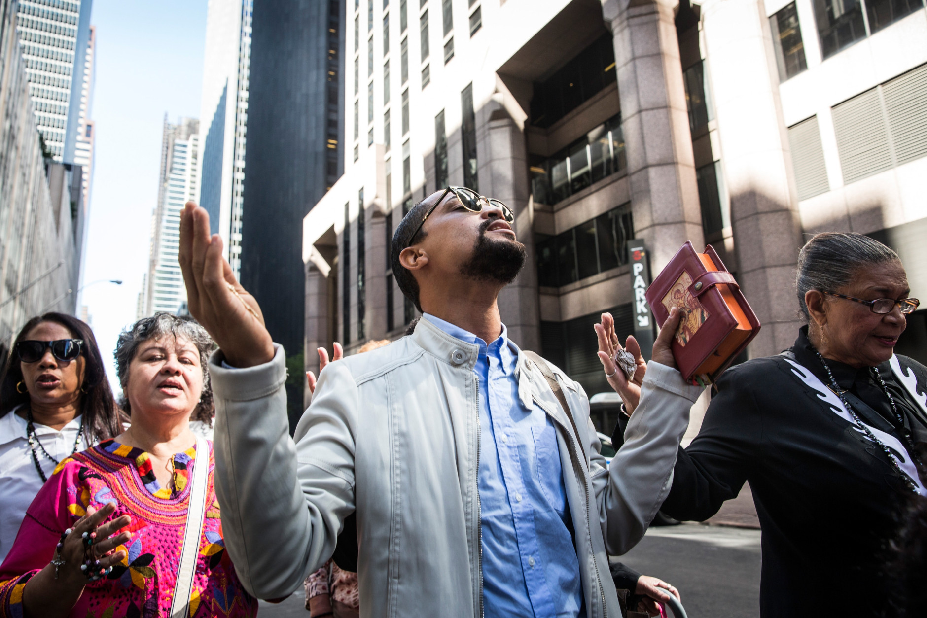 NEW YORK, NY - SEPTEMBER 24:  Yankei Mauricio leads prayers while waiting in line to stand along 5th Avenue to watch as Pope Francis drives by while he is en route to St. Patrick's Cathedral on September 24, 2015 in New York City.  The Pope will speak tonight at St. Patrick's Cathedral; he is scheduled to land at John F. Kennedy Airport at 5P.M. this evening.  (Photo by Andrew Burton/Getty Images)