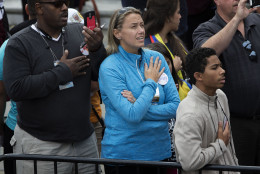 People hold their hands over their hearts during the singing of the National Anthem  on Independence Mall before the arrival of  Pope Francis in Philadelphia on Saturday, Sept. 26, 2015. The pope is visiting the city in his first visit to the United States as part of the World Meeting of Families. (AP Photo/Laurence Kesterson, pool)
