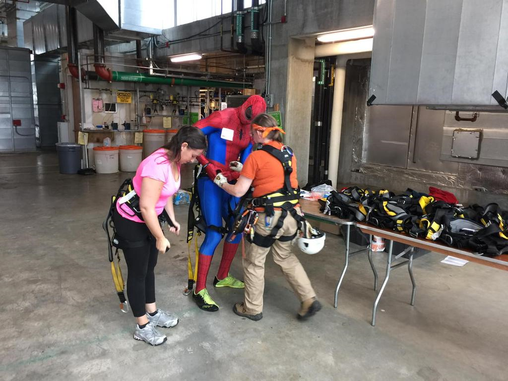 WTOP's Samantha Loss and Spider-Man get ready to rappel off the 15-story 2 Bethesda Metro building. (WTOP/Kristi King)