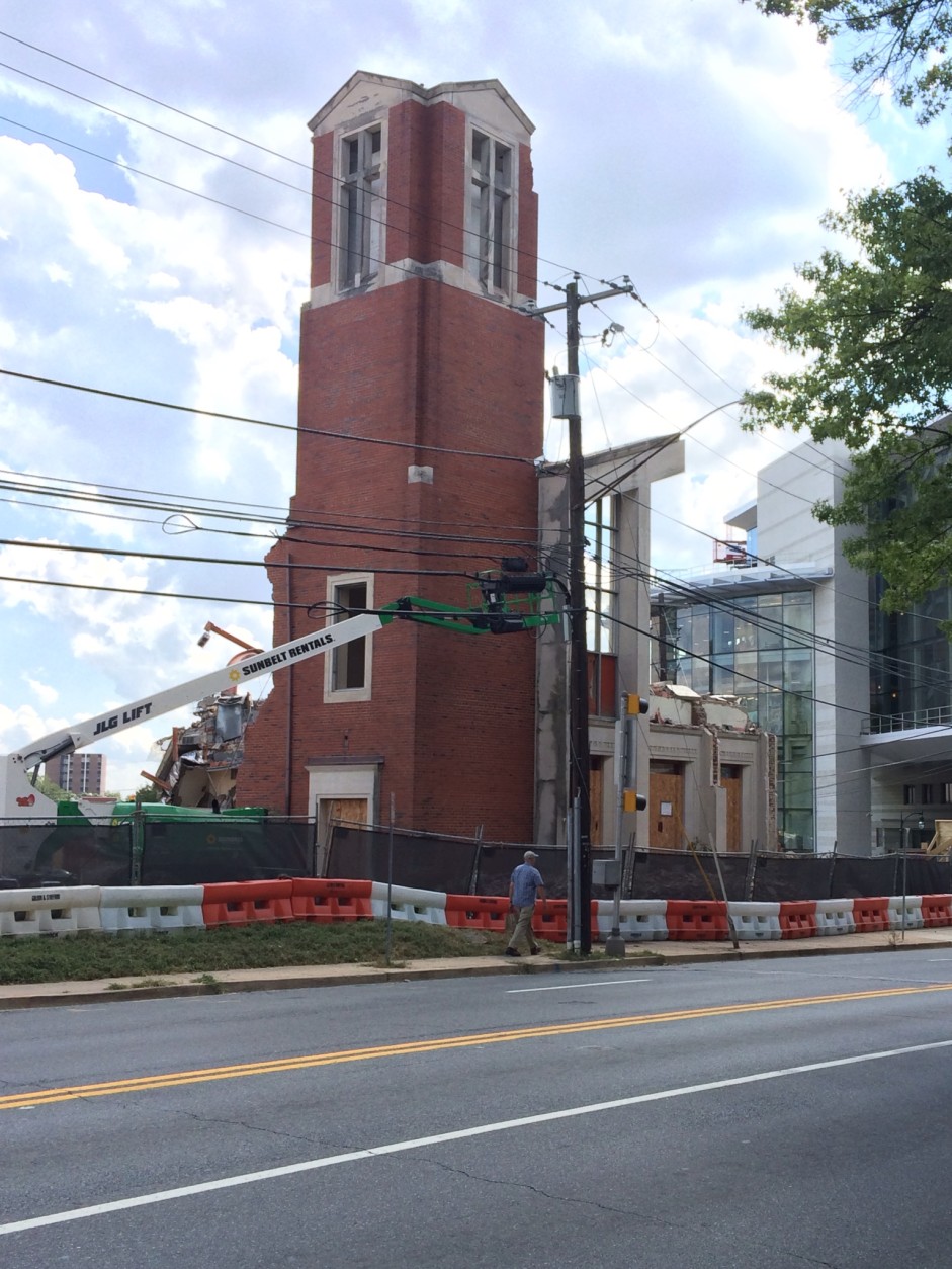 A bell tower and three front doors are all that remain of the red brick First Baptist Church of Silver Spring. The building is being demolished  to make way for new  construction, in an unusual partnership between church and commercial developers, backed by Montgomery County government leaders. (WTOP/Dick Uliano)
