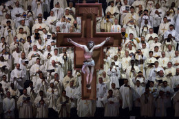 A crucifix hangs above member of the clergy who watch as Pope Francis, not shown, celebrates high Mass at Madison Square Garden, Friday, Sept. 25, 2015, in  New York. (Michael Appleton/The New York Times via AP, Pool)