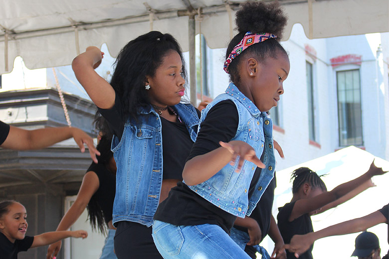 Young dancers perform on a stage on H street. (WTOP/Dana Gooley)