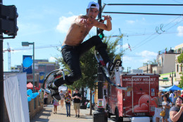 A shirtless guy on futuristic pogo stick shoes entertained crowds during the festival. (WTOP/Dana Gooley)