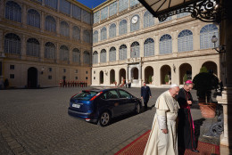 Pope Francis talks with the prefect of the papal household, Archbishop Georg Gänswein. The pontiff’s blue Ford Focus is visible behind him. (Dave Yoder/National Geographic)