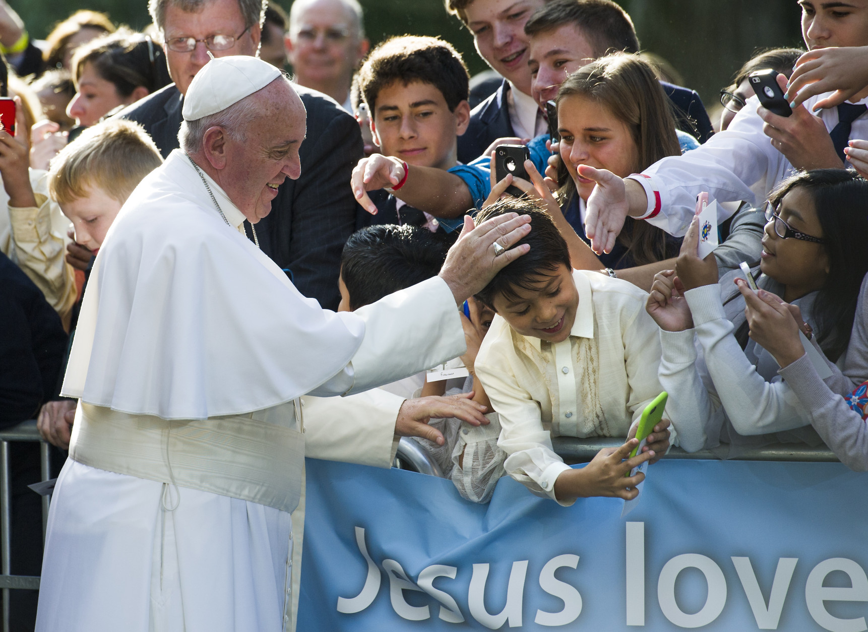Pope Francis places his hand atop a young boys head while the boy takes a selfie before the Pope departs the Apostolic Nunciature, the Vatican's diplomatic mission in the heart of Washington, en route to the Capitol to address a joint meeting of Congress Thursday, Sept. 24, 2015.  (AP Photo/Cliff Owen)
