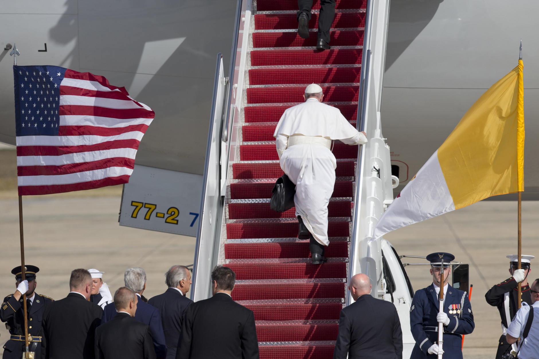 Pope Francis carries his own briefcase up the stairs before boarding his plane before leaving from Andrews Air Force Base, Md., en route to New York, Thursday, Sept. 24, 2015. (AP Photo/Jacquelyn Martin)