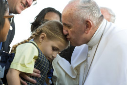 Pope Francis kisses Maria Teresa Heyer, a 1st grade student from the Brooklyn borough of New York, as the pope is greeted by Heyer and other students who gave him gifts as he arrives at John F. Kennedy International Airport Thursday, Sept. 24, 2015, in New York.  (AP Photo/Craig Ruttle, Pool)