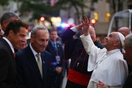 Pope Francis waves to the crowd as he arrives at St. Patrick's Cathedral, Thursday, Sept. 24, 2015 in New York. New York Gov. Andrew Cuomo, left, and Sen. Chuck Schumer, D-NY, wait to greet the pope. (Damon Winter/The New York Times via AP, Pool)