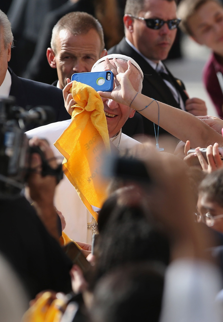 NEW YORK, NY - SEPTEMBER 25:  School children take selfies with Pope Francis upon his arrival to the Lady Queen of Angels school on September 25, 2015 in the Harlem neighborhood of New York City. The Pope visited the inner city Catholic school in east Harlem and met with children, immigrants and Catholic Charities workers on the second day of his visit to New York City.  (Photo by John Moore/Getty Images)