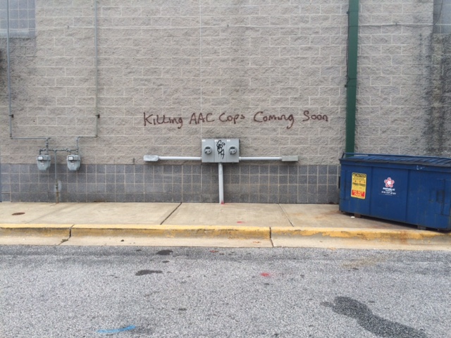 Anne Arundel County Police released this photo of vandalism to a wall at the Ritchie Highway Shopping Center. "Killing AAC Cops Coming Soon"  was spray-painted on two other walls at the shopping center. (Anne Arundel County Police Department)