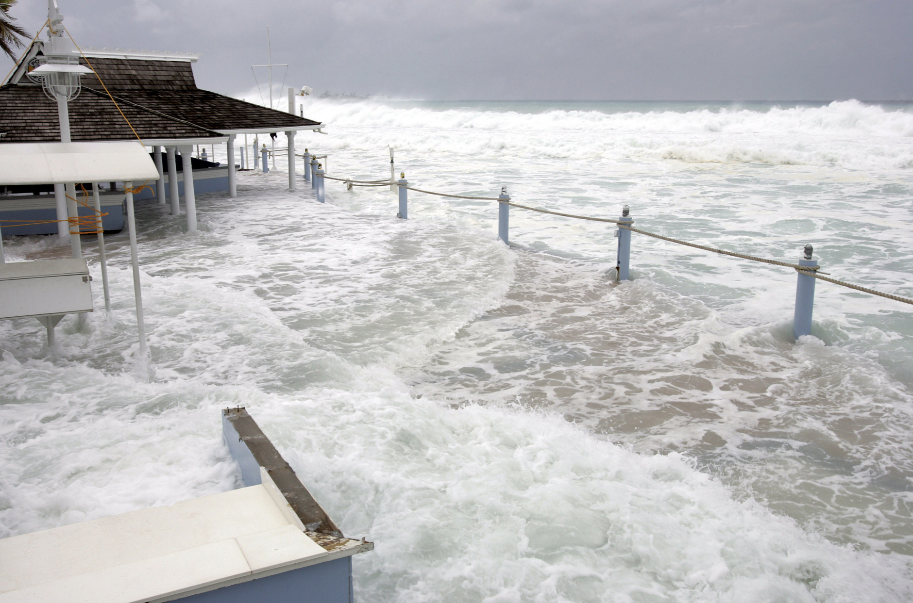 Waves reach The Wharf patio restaurant, damaging the bar and main deck, in George Town, Grand Cayman Island, Thursday, Oct. 20, 2005. Hurricane Wilma moved away from the Cayman Islands but residents and tourists are still feeling rough seas and battering waves on the south and west coasts. (AP Photo/Caymanian Compass, Justin Uzzell)