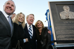 Los Angeles Dodgers owner Frank McCourt, left, wife Jamie, and Vin Scully, second from left, with wife Sandra, pose for photos next to a plaque honoring Scully before the start of an exhibition baseball game between the Los Angeles Dodgers and Boston Red Sox, Saturday, March 29, 2008 at the Los Angeles Coliseum in Los Angeles. The exhibition contest is part of the 50th anniversary of the Dodgers' move west from Brooklyn and is expected to draw a record crowd of over 115,000. (AP Photo/Branimir Kvartuc)
