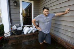 Jan-Patrick Gros looks out from his front porch of his home in the Ashborough subdivision near Summerville, S.C., Tuesday, Oct. 6, 2015. Residents are concerned that the Ashley river will continue to rise as floodwaters come down from Columbia. "I'm expecting another 2-3 feet", Gros said.  (AP Photo/Mic Smith)