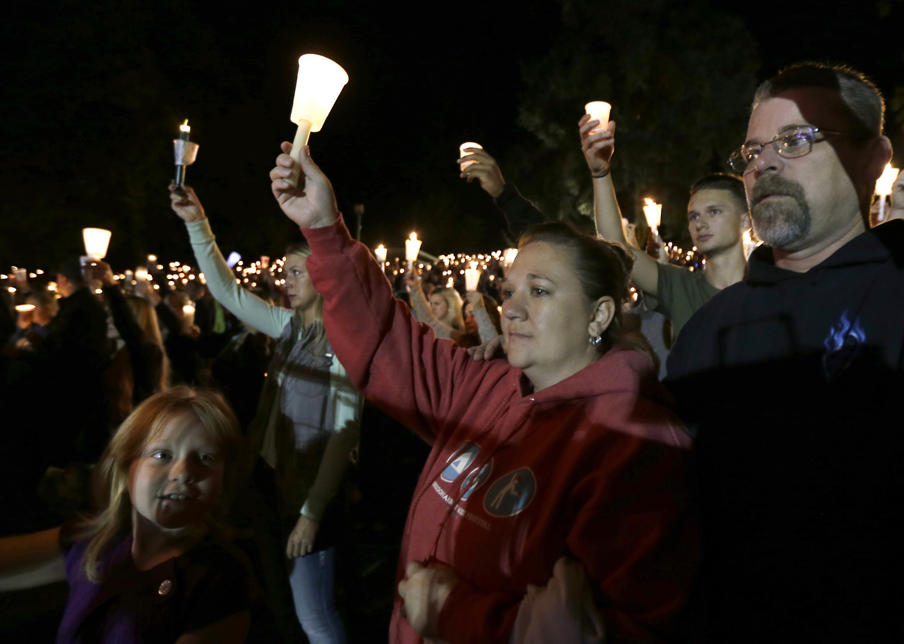 Mourners hold up candles during a candle light vigil at Stewart Park, in Roseburg, Ore., for those killed during a fatal shooting at nearby Umpqua Community College, Thursday, Oct. 1, 2015. (AP Photo/Rich Pedroncelli)