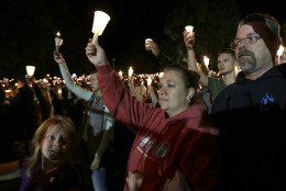Mourners hold up candles during a candle light vigil at Stewart Park, in Roseburg, Ore., for those killed during a fatal shooting at nearby Umpqua Community College, Thursday, Oct. 1, 2015. (AP Photo/Rich Pedroncelli)