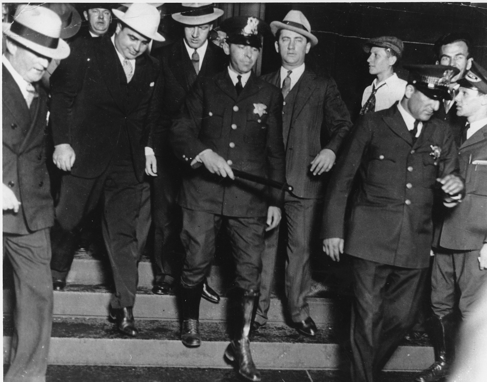 Chicago crime boss Al Capone, left, wearing white hat, is in the custody of U.S. marshals as he leaves the courtroom in Chicago on October 12, 1931. Capone was convicted on tax evasion charges. (AP Photo)