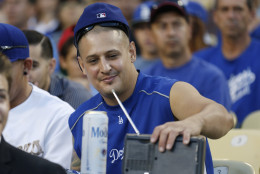 A Los Angeles Dodgers fan listens to announcer Vin Scully on a radio while attending a baseball game at Dodger Stadium against the Los Angeles Angels, Monday, August 4, 2014, in Los Angeles. (AP Photo/Danny Moloshok)