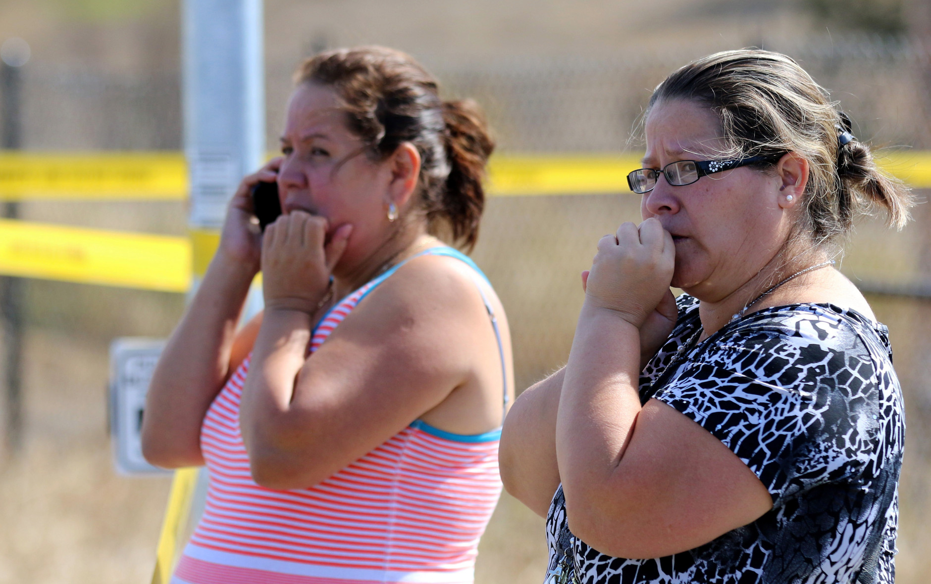Two woman wait outside Umpqua Community College campus after a shooting at the school in Roseburg, Ore., on Thursday, Oct. 1, 2015.   (AP Photo/Ryan Kang)