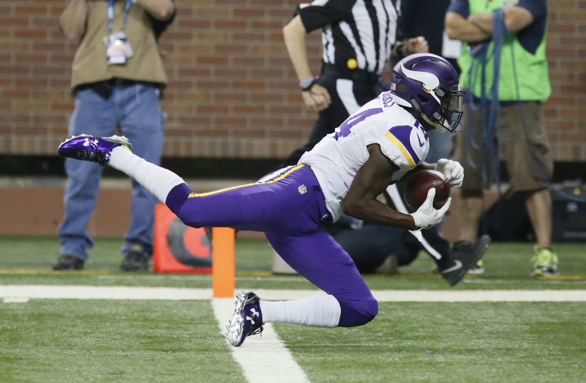 Minnesota Vikings wide receiver Stefon Diggs (14) falls into the end zone after a 36-yard reception for a touchdown during the second half of an NFL football game against the Detroit Lions, Sunday, Oct. 25, 2015, in Detroit. (AP Photo/Duane Burleson)