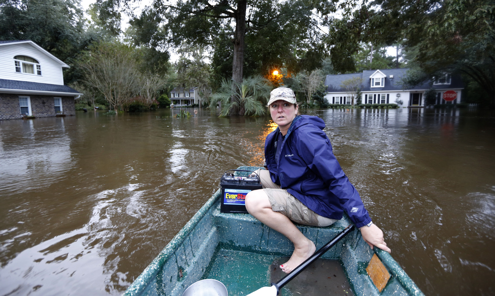 Jeanni Adame rides in her boat as she checks on neighbors seeing if they want to evacuate  in the Ashborough subdivision near Summerville, S.C., after many of their neighbors left, Monday, Oct. 5, 2015. South Carolina is still struggling with flood waters due to a slow moving storm system. (AP Photo/Mic Smith)