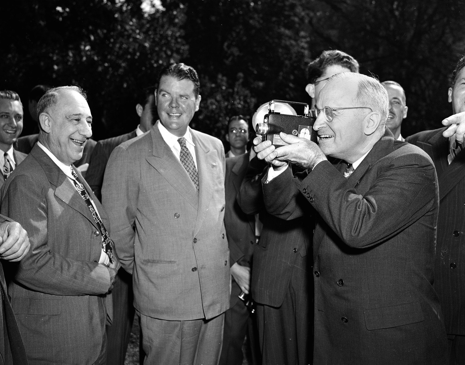 President Harry Truman operates a movie camera during a picture-taking session on the south grounds of the White House, Oct. 5, 1947.  The subjects were members of the White House News Photographers' Association, who presented the movie camera and a still camera to the president in a brief ceremony.  Others are unidentified.  (AP Photo/Harvey Georges)