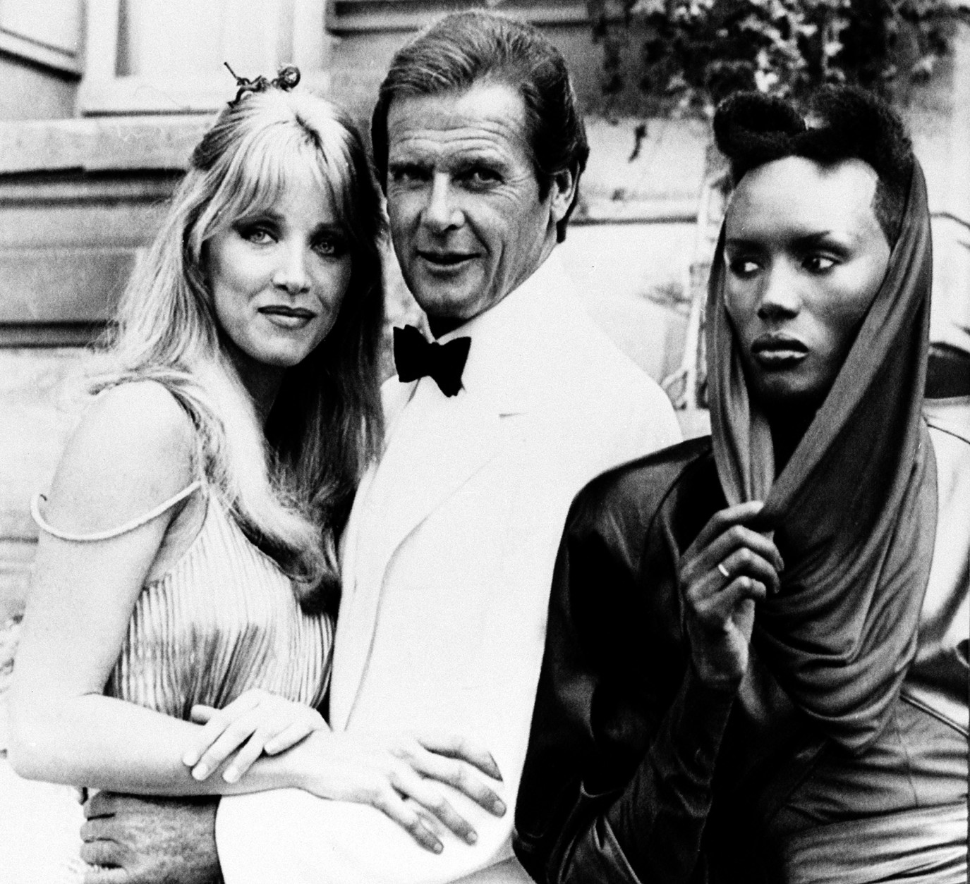 FILE - In this Aug. 17, 1984 file photo, actor Roger Moore, alias British secret agent James Bond, is seen with his co-stars Tanya Roberts, and Grace Jones, right, in front of Chateau de Chantilly, on the set of the 007 action film "A View to a Kill," near Paris, France. (AP Photo/Alexis Duclos, File)