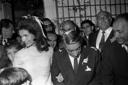 With daughter Caroline peeking over her right shoulder, Jacqueline Kennedy Onassis leaves the chapel with her new husband, Greek shipping magnate Aristotle Onassis, after their wedding on the Greek Island of Scorpios, Oct. 20, 1968.  (AP Photo/Jim Pringle)