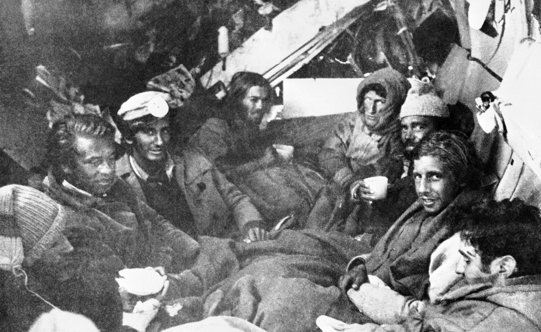 The last eight survivors of the Uruguayan Air Force plane crash in the Andes in South America, huddle together in the craft's fuselage on their final night before rescue on Dec. 27, 1972. A mountain rescue team brought them food. (AP Photo)