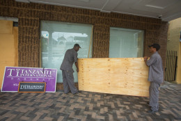 Perry Williams, 47, left, and Alaric Nixon, 28, carry a sheet of plywood as they cover the windows of the Diamond's International store, in preparation for the arrival of hurricane Joaquin in Nassau, Bahamas, Thursday, Oct. 1, 2015. Hurricane Joaquin unleashed heavy flooding as it roared through sparsely populated islands in the eastern Bahamas as a Category 4 storm, with forecasters warning it could grow even stronger before carving a path that would take it near the U.S. East Coast. (AP Photo/Tim Aylen)