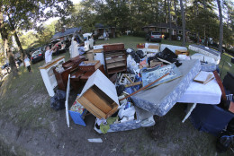 A man clears debris outside a flood damaged home  in Columbia, S.C. (AP Photo/John Bazemore)
