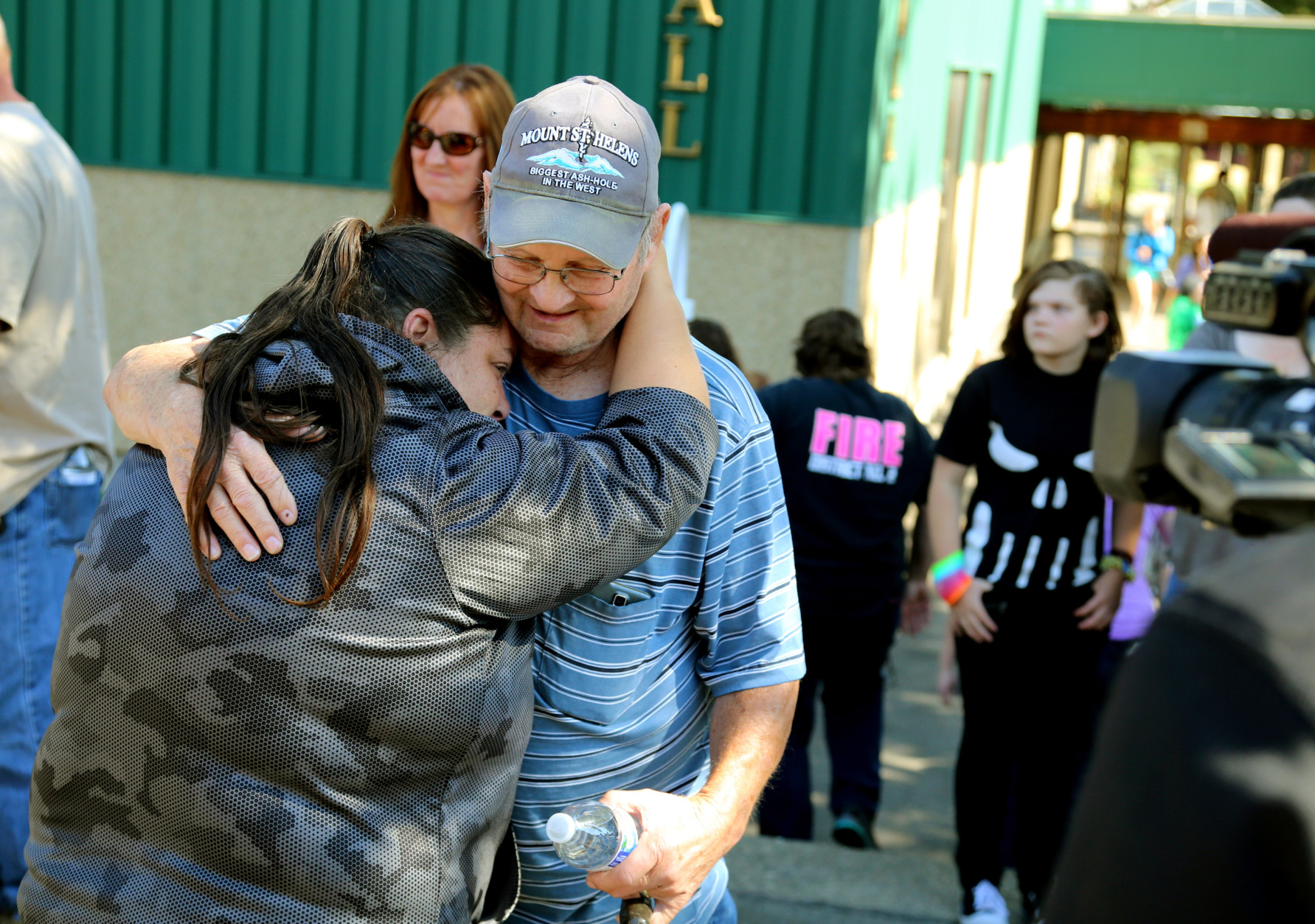 Friends and family are reunited with students at the local fairgrounds after a deadly shooting at Umpqua Community College, in Roseburg, Ore., Thursday, Oct. 1, 2015. (AP Photo/Ryan Kang)