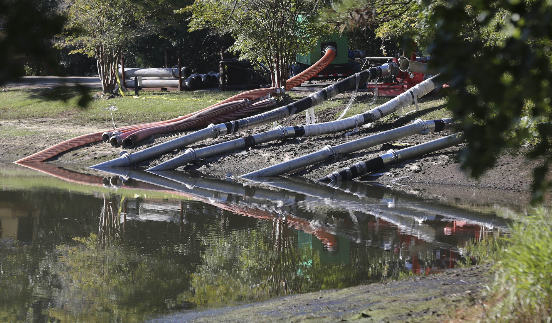 Work crews use an pumps to lower water levels and stabilize a dam at a lake, Wednesday, Oct. 7, 2015, in Columbia, S.C. Heavy rain has caused flooding in parts of the state. (AP Photo/John Bazemore)