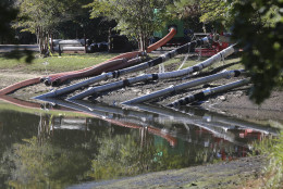 Work crews use an pumps to lower water levels and stabilize a dam at a lake, Wednesday, Oct. 7, 2015, in Columbia, S.C. Heavy rain has caused flooding in parts of the state. (AP Photo/John Bazemore)