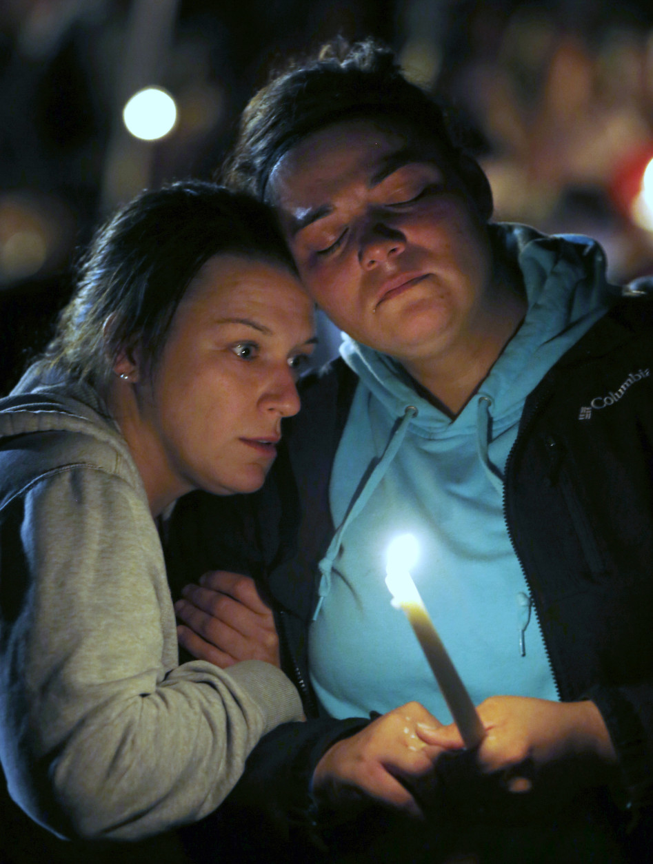 Angel Martinez, left, comforts Brenda Valenzuela during a candle light vigil for those killed during a fatal shooting at Umpqua Community College, Thursday, Oct. 1, 2015, in Roseburg, Ore. Valenzuela was on campus and saw the gunman. (AP Photo/Rich Pedroncelli)
