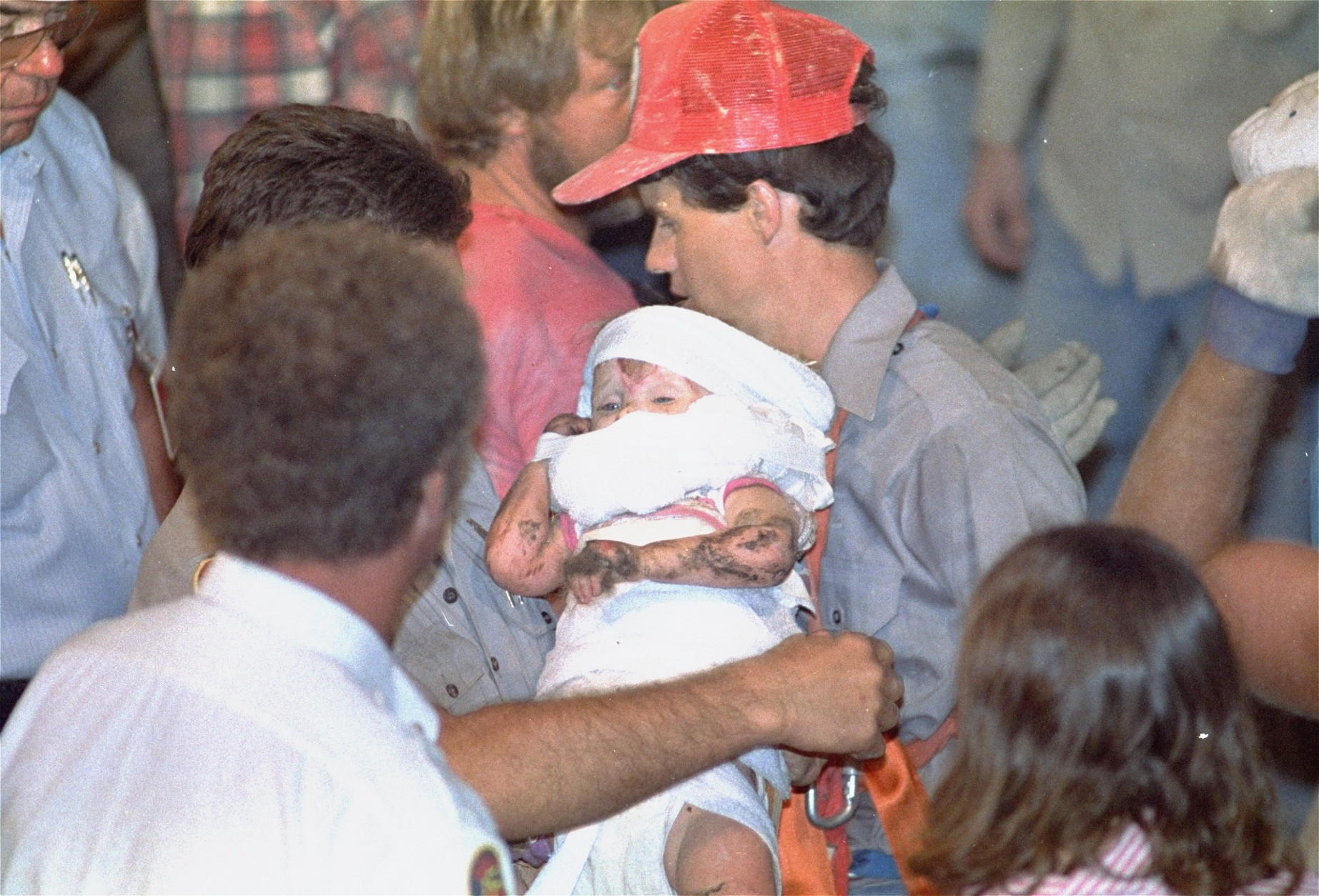 Eighteen-month old Jessica McClure is held by rescue worker Steven Forbes Friday night, Oct. 16, 1987 after she was trapped 22 feet under ground in an abandoned water well since Wednesday morning.  (AP Photo/Eric Gay)