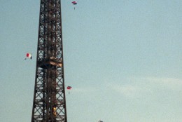 Some of 75 parachutists sail by Paris' Eiffel Tower Wednesday, Oct. 22, 1997 to celebrate the 200th anniversary of the first parachute jump. The first parachutist was a 28-year-old French physician named Andre-Jacques Garnerin. In 1797, he flew 1,300 feet above Monceau Park in Paris in a hot-air balloon, when he cut the balloon free and released a parachute that lowered him to the ground safely, except for a sprained ankle. Electric sign on the Eiffel Tower counts down the days until the year 2000. (APPhoto/Michel Lipchitz)