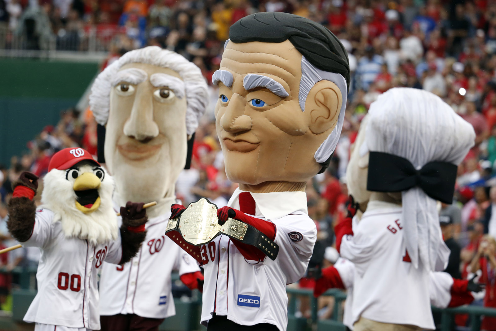 Racing President mascot President Calvin Coolidge holds the winner's belt after winning his first race during the fourth inning of a baseball game between the Washington Nationals and the San Francisco Giants at Nationals Park, Friday, July 3, 2015, in Washington. (AP Photo/Alex Brandon)